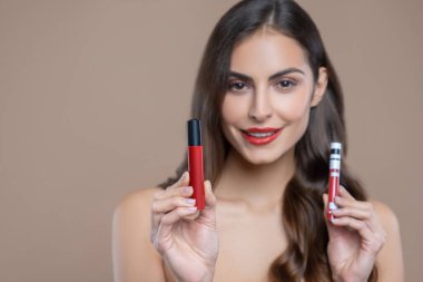 Dudak parlatıcısı olan kadın kırmızının tonunu seçiyor.