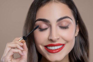 Siyah rimelle kirpiklerini boyayan mutlu kadın.