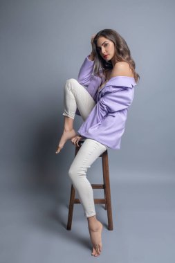 Stüdyoda çıplak omuzlu düşünceli güzel bir kadın.