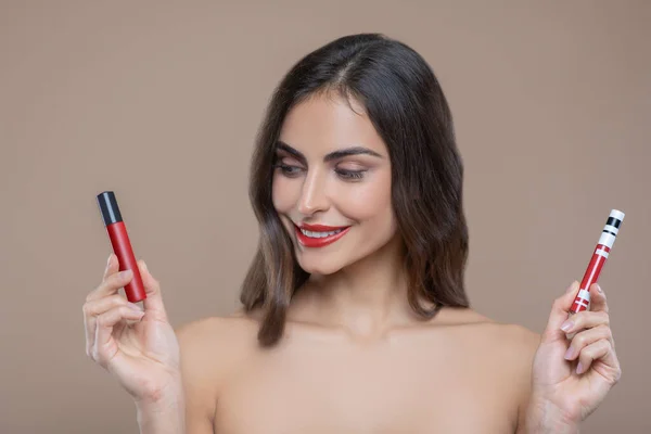Женщина с двумя оттенками красного блеска для губ — стоковое фото