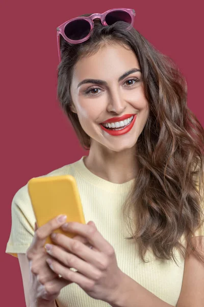 Close-up de mulher bonita feliz com smartphone amarelo — Fotografia de Stock