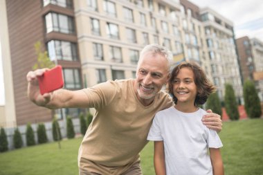 Bir baba ve oğul kendilerini iyi hissediyorlar ve selfie çekiyorlar.