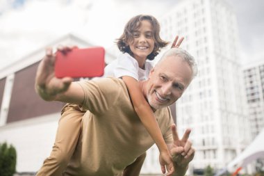 Bir baba ve oğul kendilerini iyi hissediyorlar ve selfie çekiyorlar.
