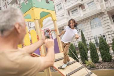 Bir baba ve bir oğul fotoğraf çekiyor ve gülümsüyor.
