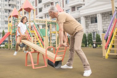 Bir çocuk ve babası çocuk parkında vakit geçiriyorlar.