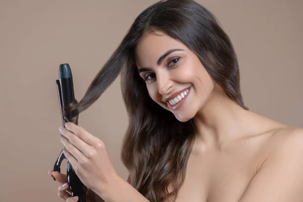Woman successfully curling her hair on curling iron