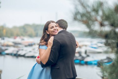 Sokakta gülümseyen güzel kadını kucaklayan adam.