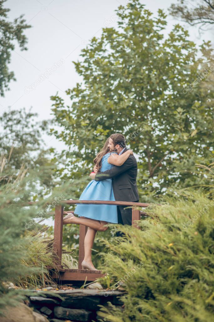 Woman and man hugging on bridge