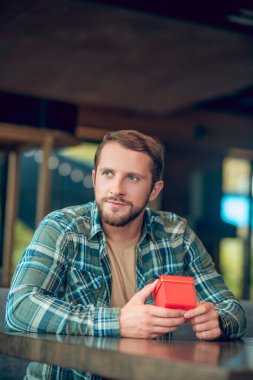 Kafede hediyeli dalgın, mutlu adam.