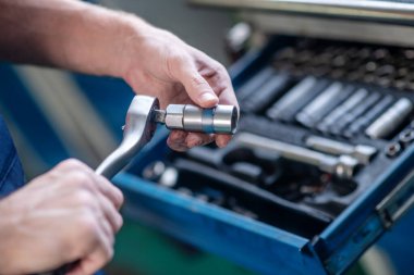 Otomatik tamir aracı olan erkek eller