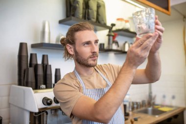 Kaldırılmış ellerde cama bakan dikkatli bir adam.