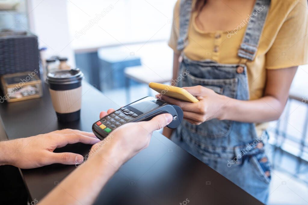 Female hands holding smartphone near poster