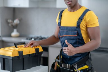 Mutfakta duran esmer tenli servis elemanı.