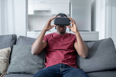 VR gözlüklü esmer tenli genç bir adam.