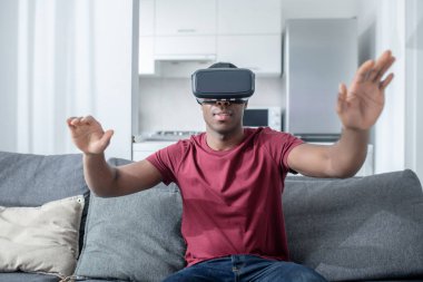 VR gözlüklü esmer tenli genç bir adam.