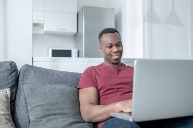 Koyu tenli genç bir adam evden çalışıyor ve olaya dahil olmak istiyor.