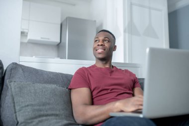 Koyu tenli genç bir adam evden çalışıyor ve olaya dahil olmak istiyor.