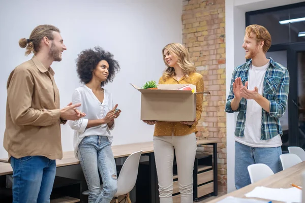 Group of colleagues wishing good luck to their leaving coworker