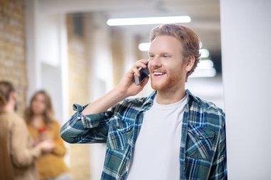 Young coworkers talking and smiling during the coffee break