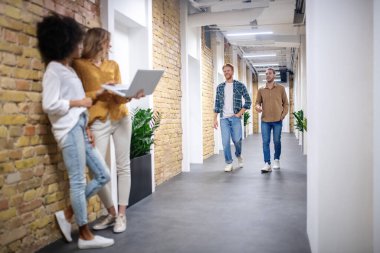 Girls watching the men coming from the other side of the corridor