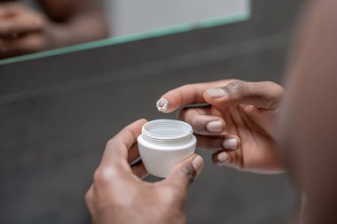 Erkek eli kremalı kavanozu kapat.