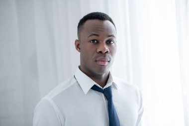 Genç bir Afrikalı Amerikalı kravat takıyor ve şık görünüyor.