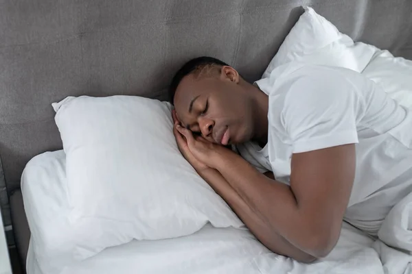 Un joven de blanco que duerme y se ve tranquilo — Foto de Stock
