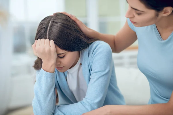 Upset daughter and soothing understanding mom touching