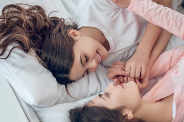 Anne gözleri kapalı yatan kızına bakıyor.