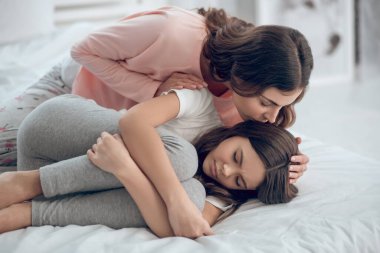 Annem eğiliyor, sarılıyor, kötü hisseden bir kız gibi yalan söylüyor.