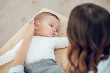 Annem uyuyan çocuğun kafasına dokunuyor.