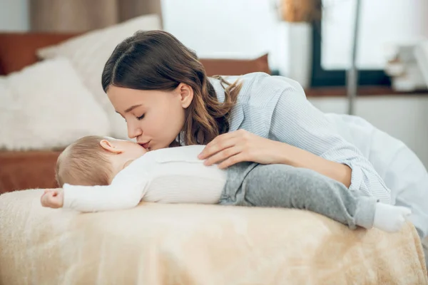 Caring mother bending over sleeping child