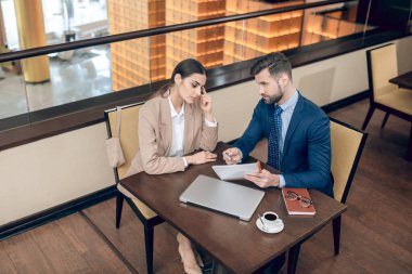 İş arkadaşları proje detaylarını ofiste tartışıyor