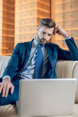 Ofiste oturan takım elbiseli yakışıklı sakallı genç adam.