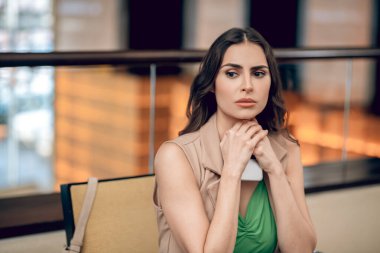 Güzel genç bir kadın bekliyor ve endişeli görünüyor.