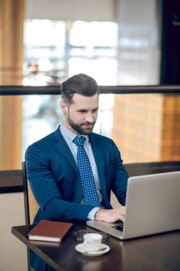 Ofiste çalışan takım elbiseli genç bir işadamı.