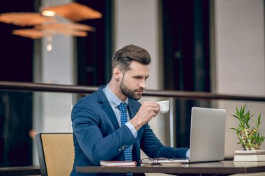 Ofiste çalışan takım elbiseli genç bir işadamı.