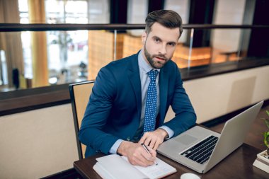 Genç yakışıklı işadamı ofiste çalışıyor.