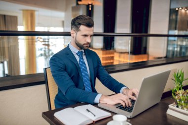 Genç yakışıklı işadamı ofiste çalışıyor.