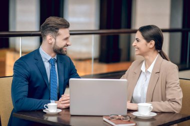 İş ortakları masada oturup sohbet ediyorlar.