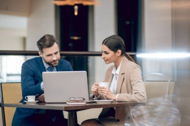 İş ortakları masada oturup projeyi tartışıyor.