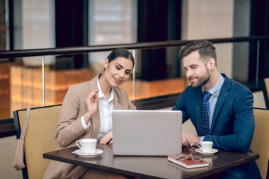 İş ortakları masada oturuyor ve beyin fırtınası yapıyorlar.