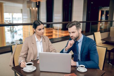 Ortaklar masada oturup olaya dahil olmuş gibi bakıyorlar.