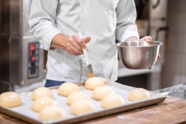 Erkek elleri, rulo şekerlemeleri kaplıyor.