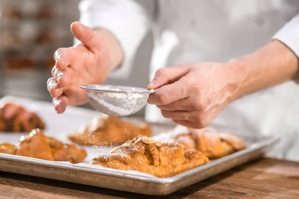 Chefs manos con tamiz pequeño sobre hornear — Foto de Stock