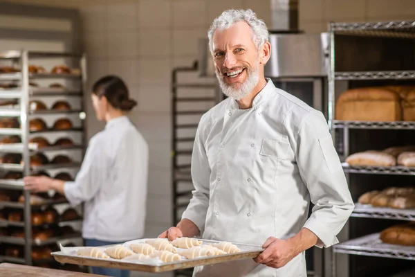 Mann mit Tablett Bagels und Frau dahinter — Stockfoto