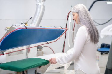 Giysileri ütüleyen kadın.