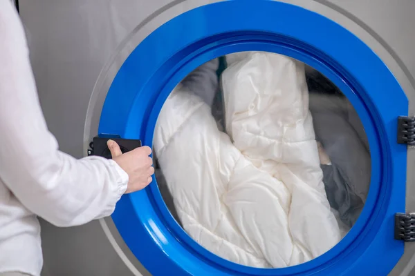 Womans mão abertura porta da máquina de lavar roupa — Fotografia de Stock
