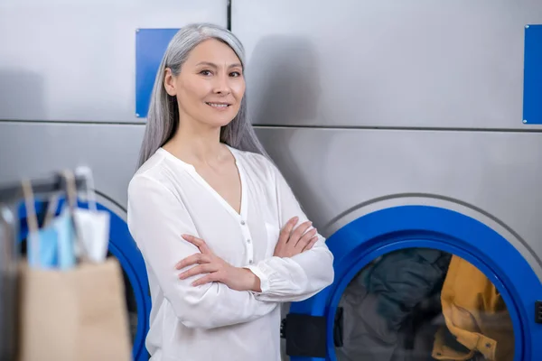 Wanita berdiri di dekat mesin cuci besar — Stok Foto