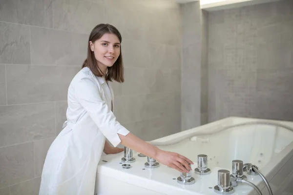 Wellness-Spezialist bereitet das Bad für die Hydromassage vor — Stockfoto